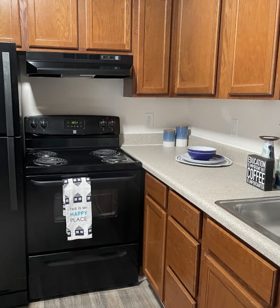 a kitchen with a stainless steel refrigerator and wooden cabinets