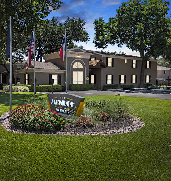 the sign for the apartments flags in front of the building