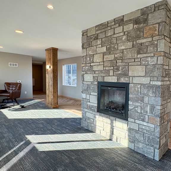 A modern living room with a stone fireplace and bar area.