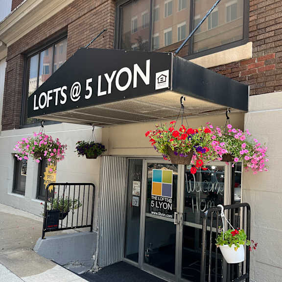 a building with a black awning and a sign that says lots of lyon
