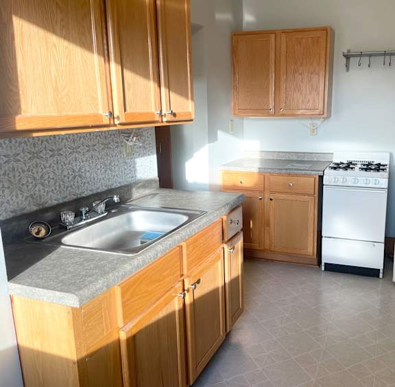 A kitchen with wooden cabinets and a white refrigerator.