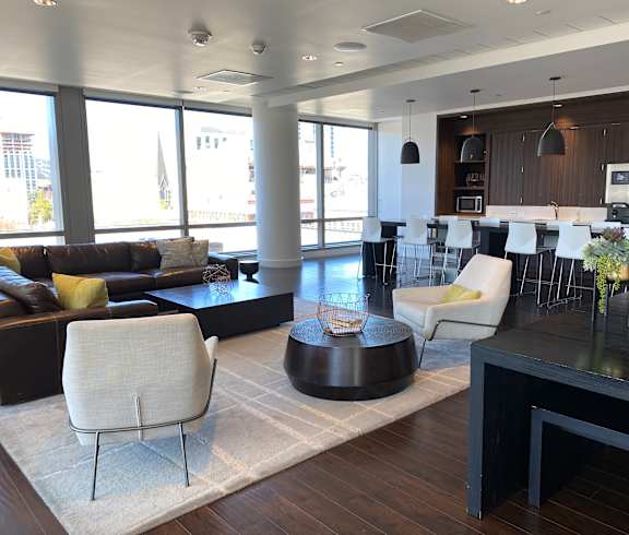 A modern living room with a black coffee table and white chairs.