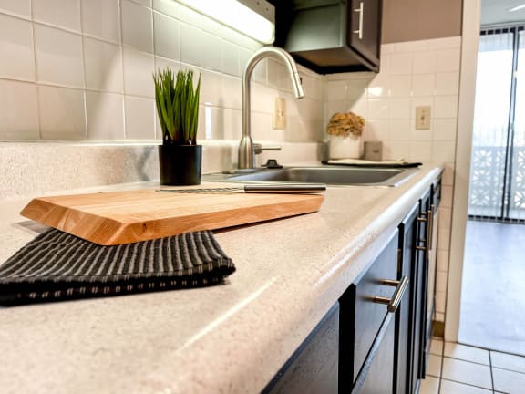 a kitchen with a cutting board on the counter and a sink