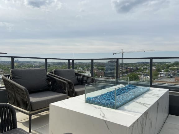 a rooftop with a luxurious fireplace and city views at Tribeca NOMA apartments