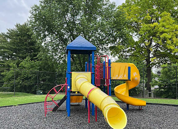 A playground with a blue and yellow slide.