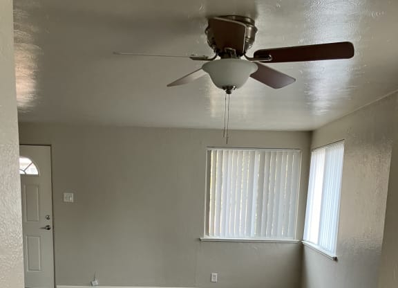 a room with a ceiling fan and a door with a window