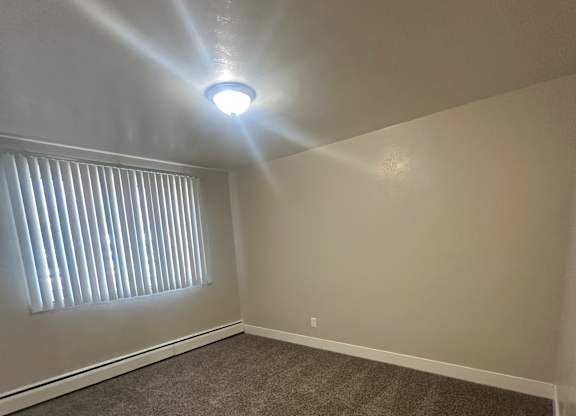 A bright light shines through a small circular opening in a wall.