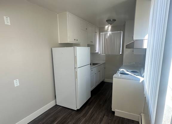 A white appliance in a room with wood paneling on the wall.