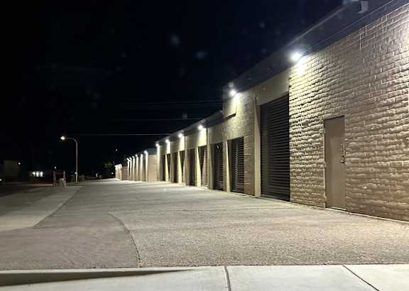 A long row of lighted garage doors at night.