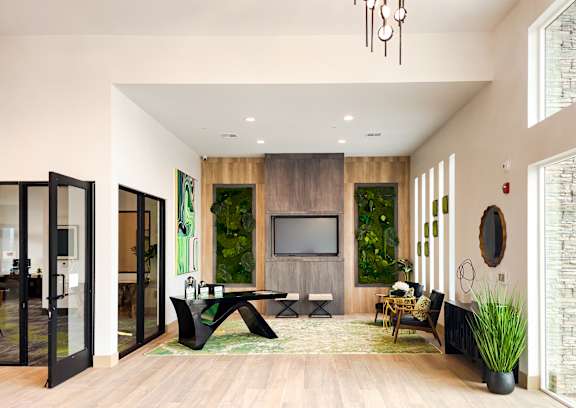 A living room with a television and a green wall.