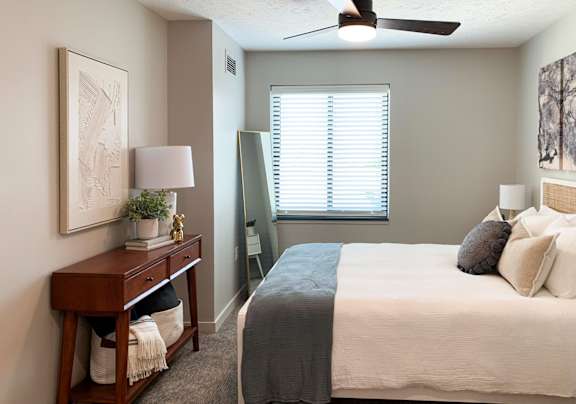 a bedroom with a ceiling fan and a window