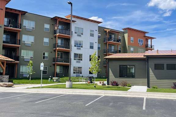 Apartment buildings with a parking lot in front.