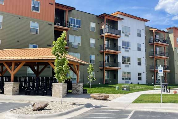 Apartment complex with a small tree in front of a building.