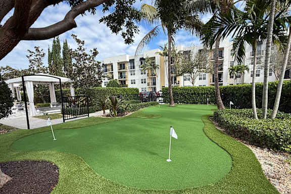 A small putting green in front of a building.