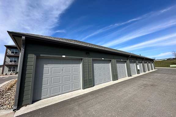 a garage with a row of garage doors and a blue sky
