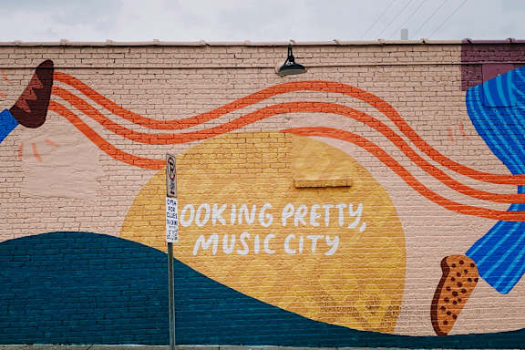 A mural on a wall with the words "Cooking Pretty Music City" written on it.