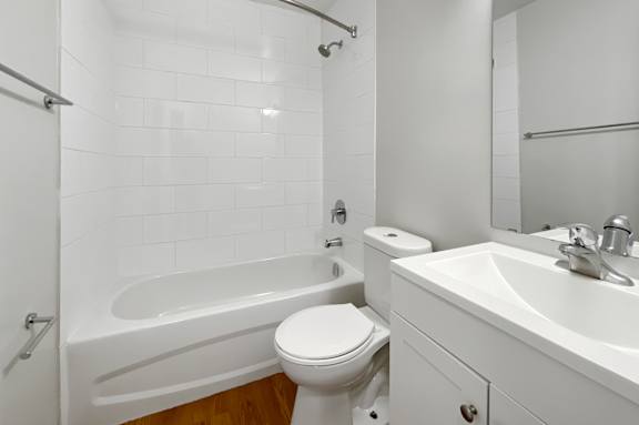 A white bathroom with a toilet, sink, and bathtub.