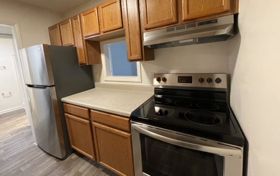 an empty kitchen with wood cabinets and stainless steel appliances