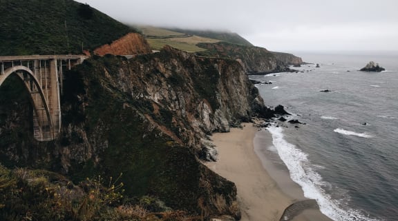 a view of the bixby creek bridge and the pacific ocean