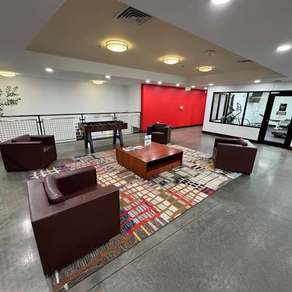 A room with a red wall and a patterned rug.