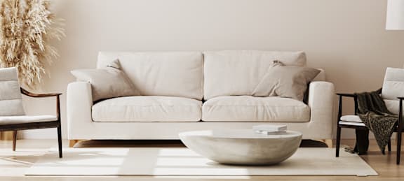 A white couch with a bowl on the floor in front of it. at Sycamore Square, Arizona, 85202