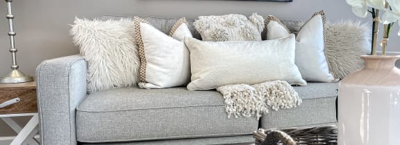 a living room with a gray couch and pillows
