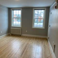 a living room with a couch and chairs and a window