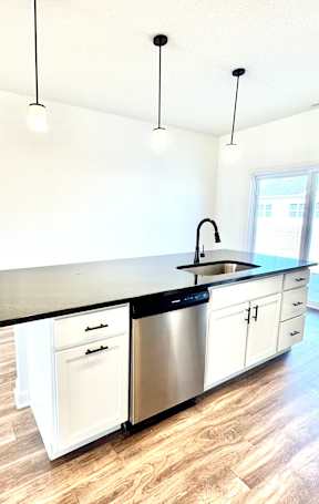 A kitchen with a black counter top and white cabinets.at Concord Crossing, Lafayette, 47909