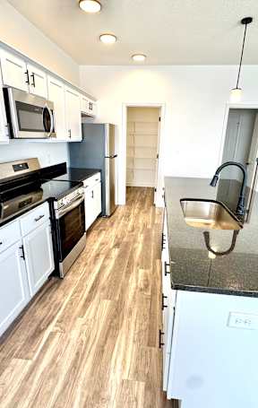 A kitchen with white cabinets and black countertops.at Concord Crossing, Lafayette, IN 47909