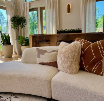 a white couch with brown and white pillows in a living room at Delco Flats, Austin, Texas