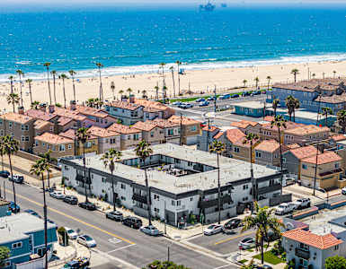 A beachfront town with a large body of water and a ship in the distance.