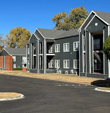 a row of houses with a red car parked in front of them at Emerald Greens, Norman, 73072