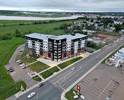 an aerial view of an apartment building on the side of a road