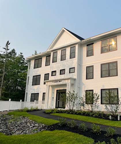 A large white building with a balcony on the second floor.