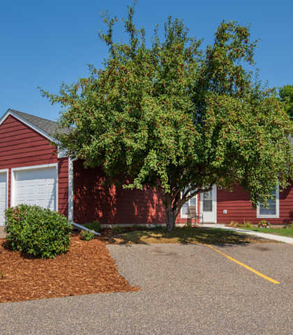 a red house with a tree in front of it