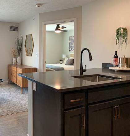 a kitchen with an island and a living room in the background