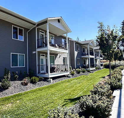 a row of houses with a lawn and a porch