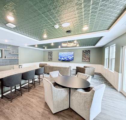 A modern dining room with a bar area and a television mounted on the wall.