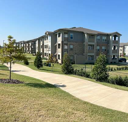 Apartment complex with a tree in front of it.