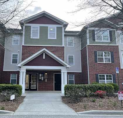 a large brick house with a sidewalk in front of it