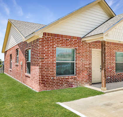 the front of a brick house with a white door