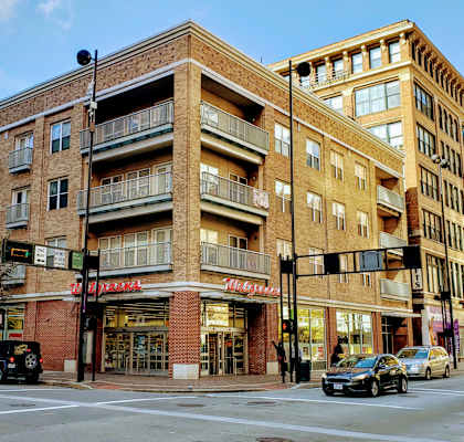 a brick building with a red sign on the corner of a street