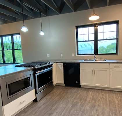 a kitchen with white cabinets and stainless steel appliances
