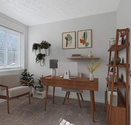 A room with a desk, chair, and a plant.
