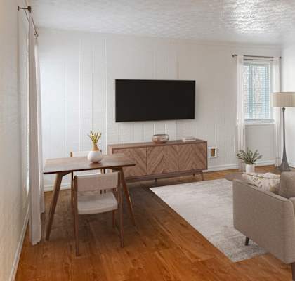A living room with a couch, chair, and television.