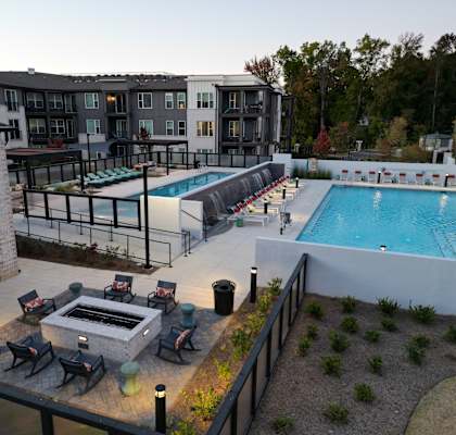 A pool area with a hot tub and lounge chairs.