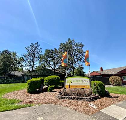 a view of the front of the summerhill park office building with flags flying in front of