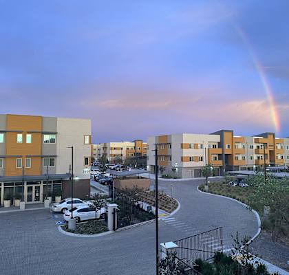 a rainbow in the sky over an apartment complex