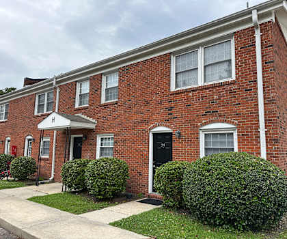 A red brick house with a black door and white trim.