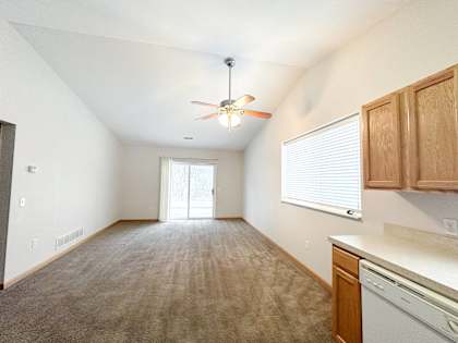 A room with a ceiling fan and a window with blinds.